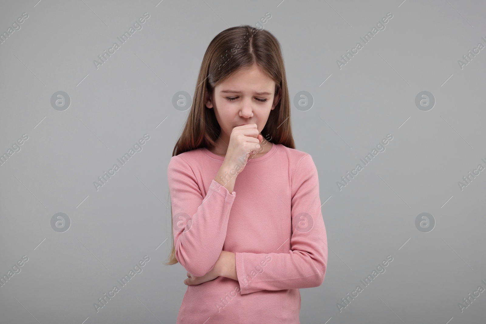 Photo of Sick girl coughing on gray background. Cold symptoms