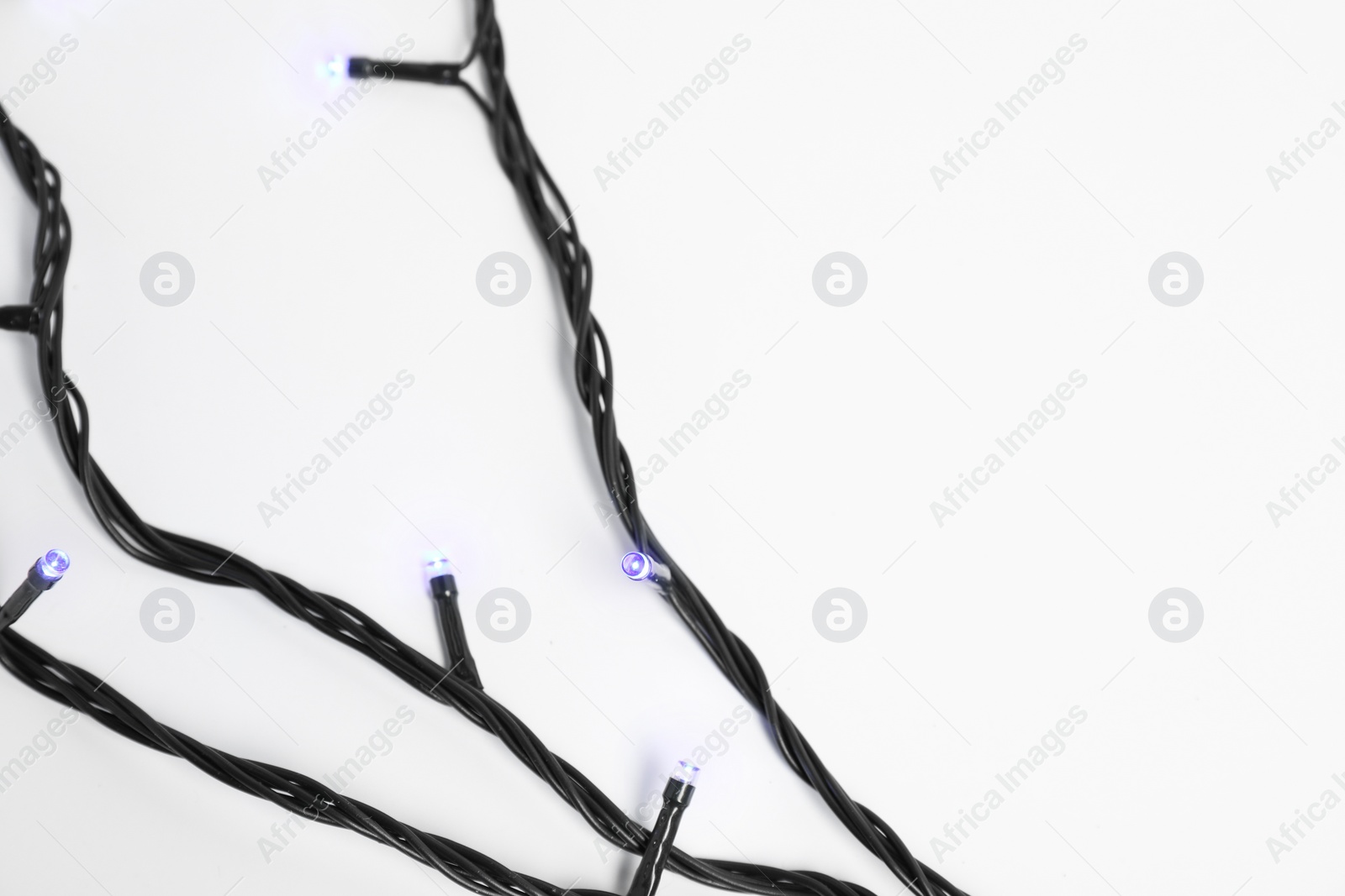 Photo of Beautiful Christmas lights on white background, top view