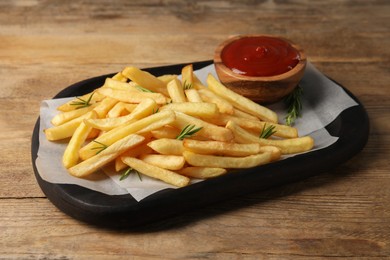 Delicious french fries served with ketchup on wooden table