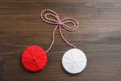Traditional martisor on wooden background, top view. Beginning of spring celebration