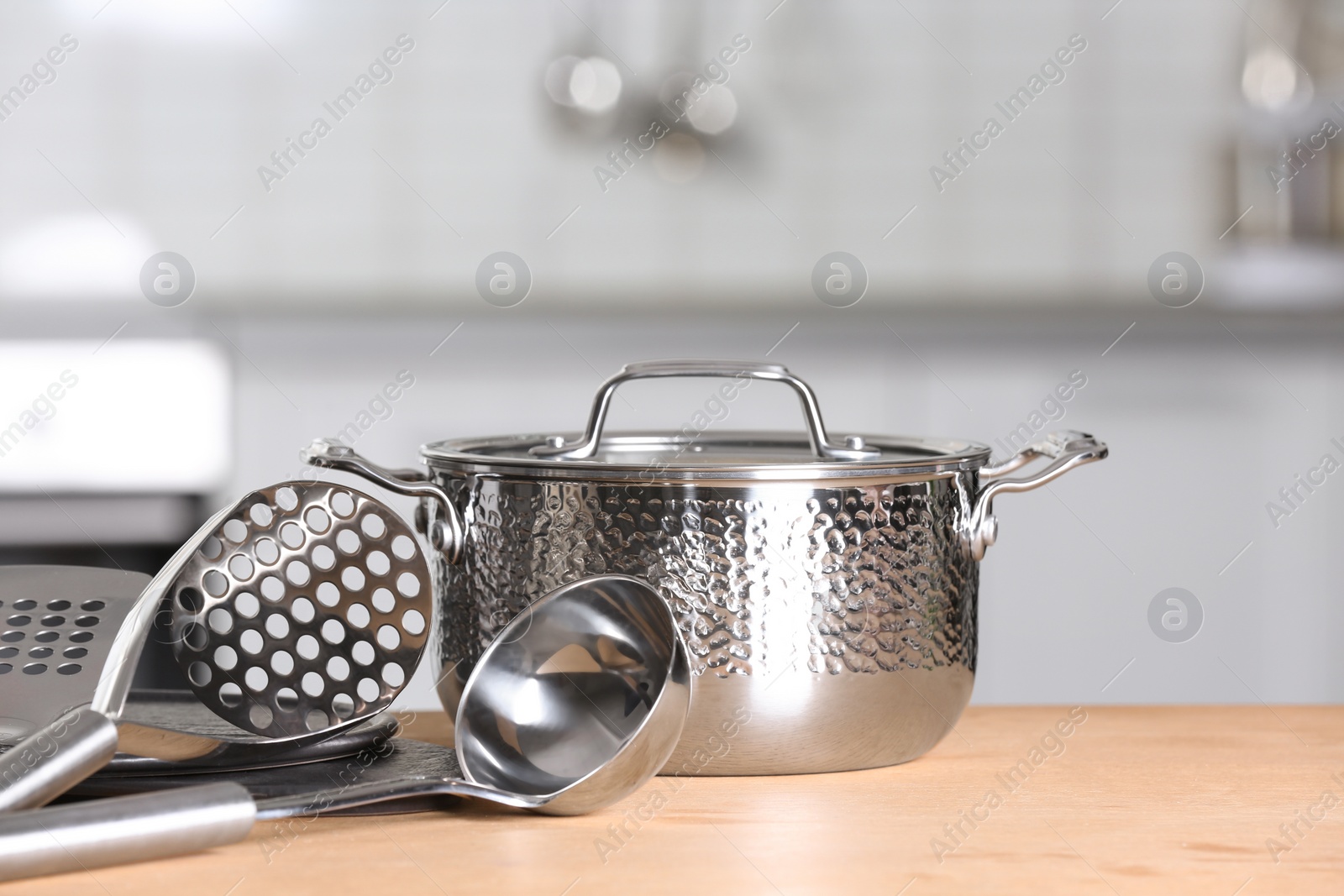 Photo of Set of clean cookware and utensils on table in kitchen