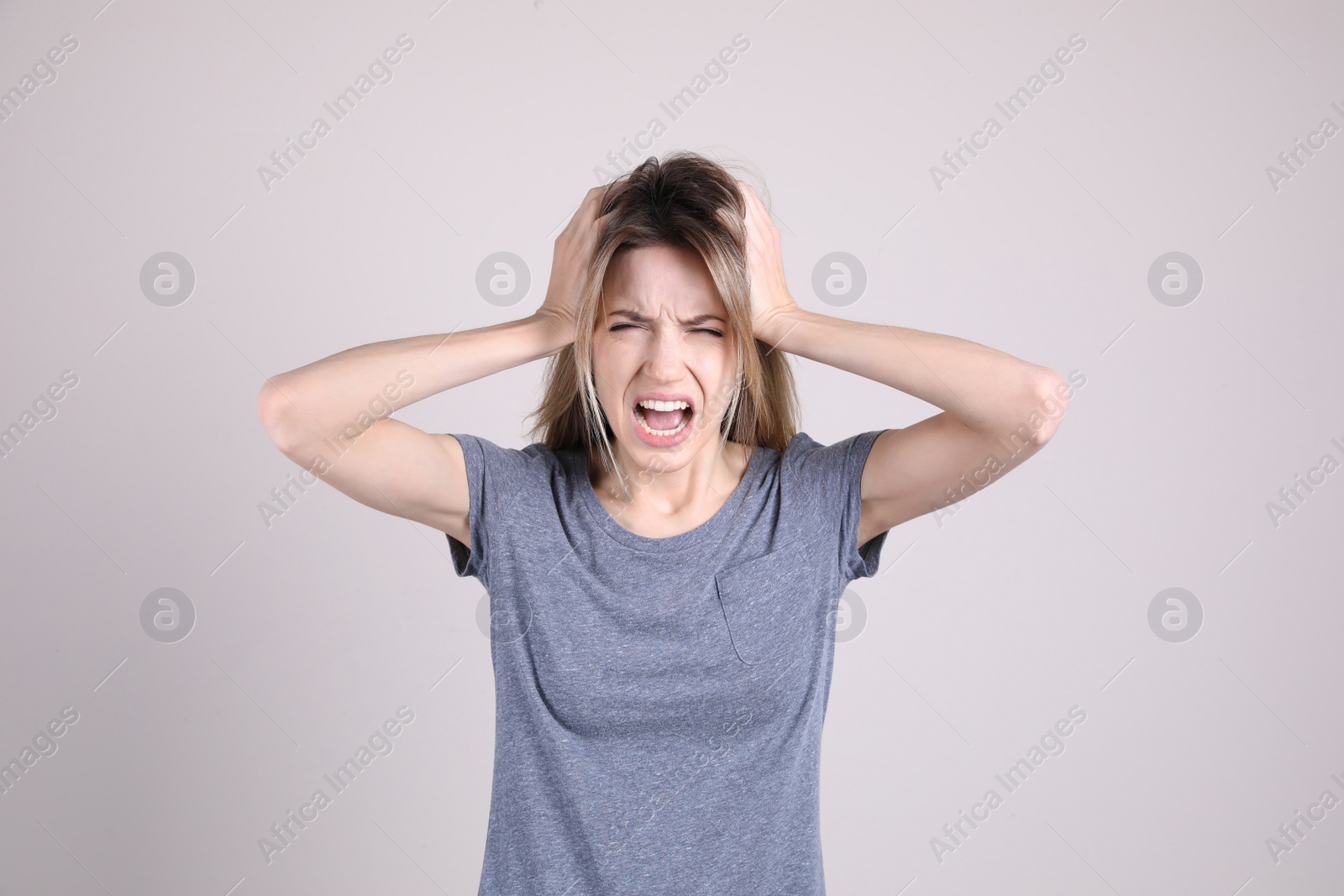 Photo of Portrait of stressed young woman on light background