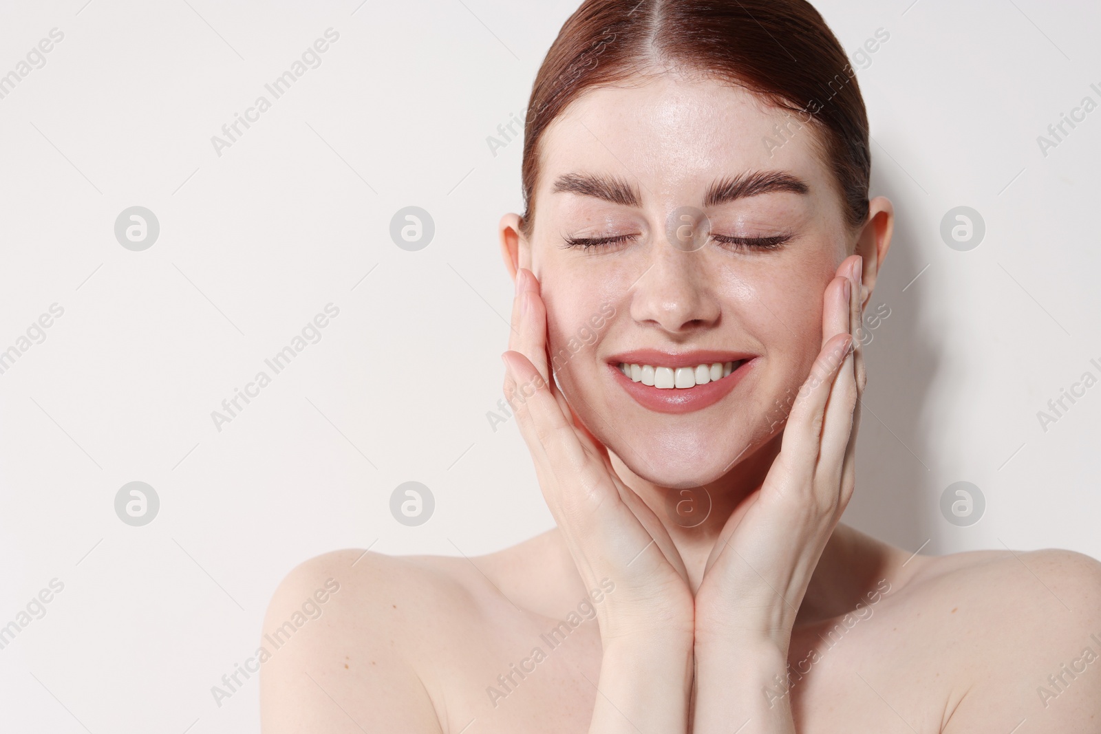 Photo of Portrait of smiling woman on light background. Space for text