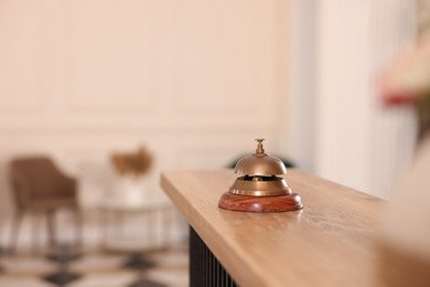 Photo of Hotel service bell on wooden reception desk. Space for text