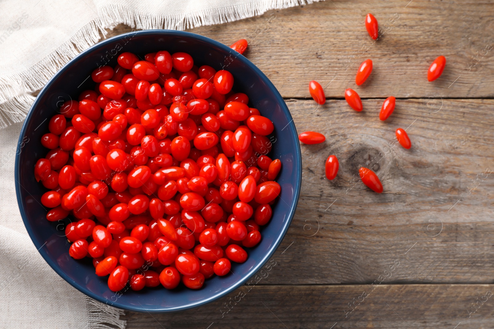 Photo of Fresh ripe goji berries on wooden table, flat lay