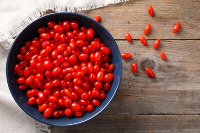 Photo of Fresh ripe goji berries on wooden table, flat lay