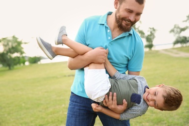 Photo of Man playing with his child outdoors. Happy family