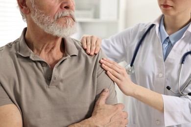 Photo of Arthritis symptoms. Doctor examining patient with shoulder pain in hospital, closeup