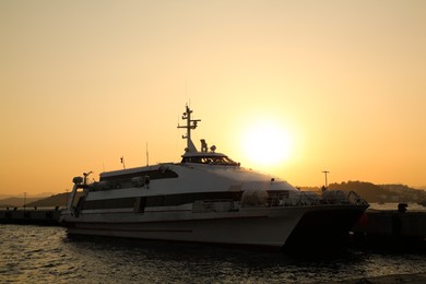 Picturesque view of ferries moored in sea port at sunset