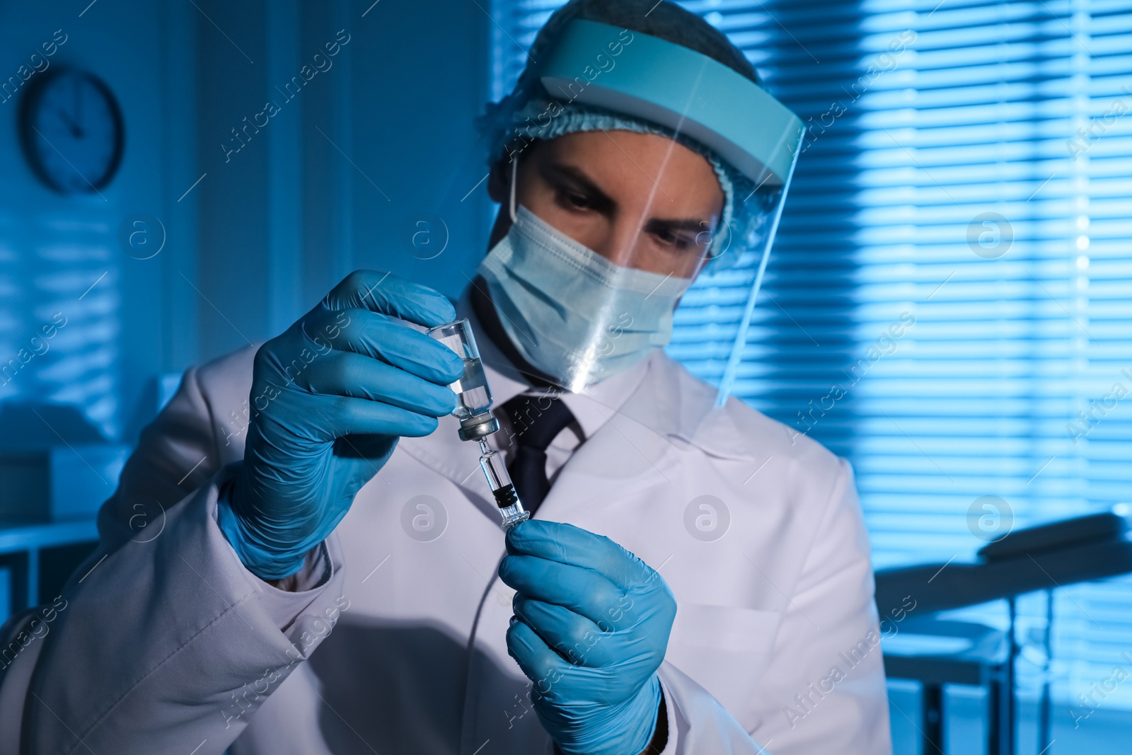 Photo of Doctor filling syringe with vaccine against Covid-19 in laboratory, focus on hands