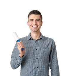 Photo of Young man with lint roller on white background. Dry-cleaning service