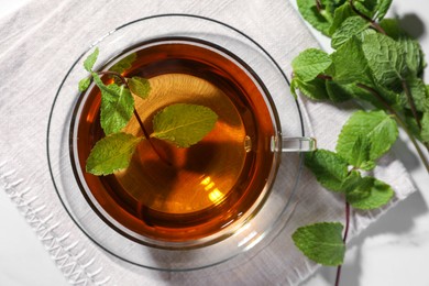 Photo of Cup of aromatic herbal tea with mint on white table, top view