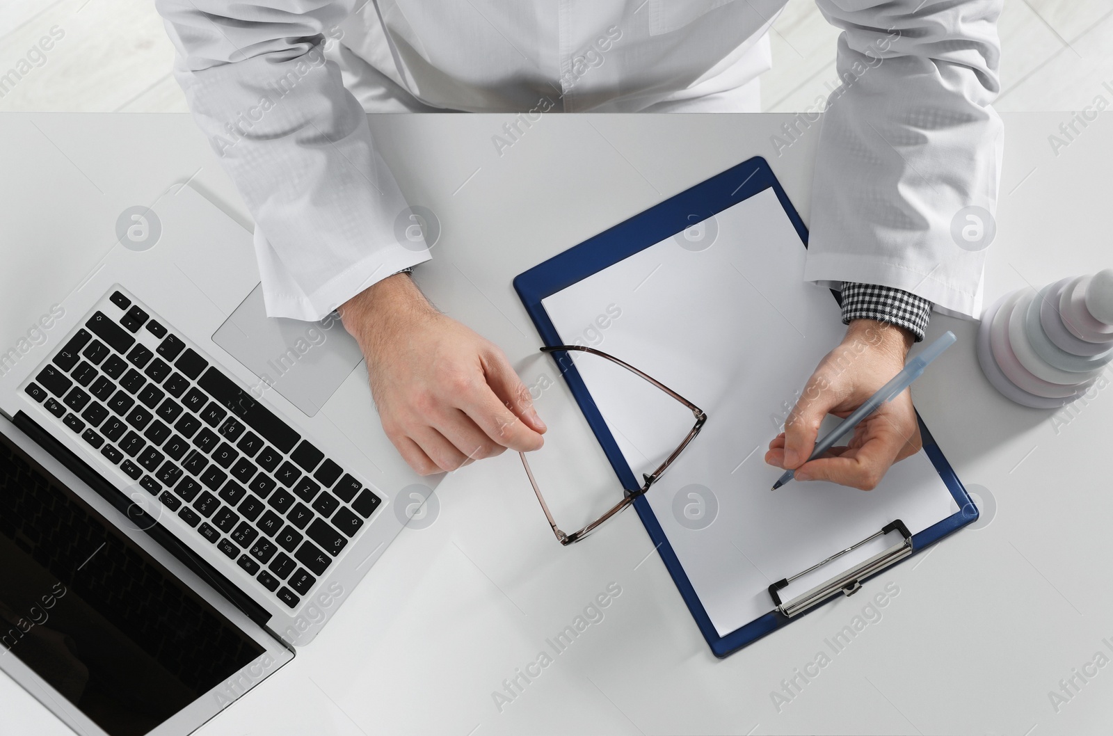 Photo of Pediatrician working at table in clinic, top view