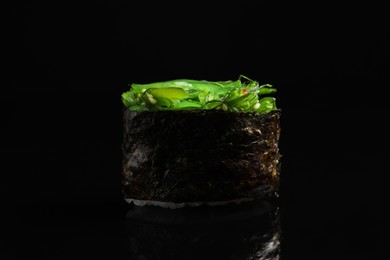 Photo of Delicious sushi with seaweed salad on black background