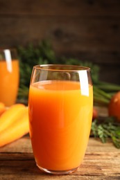 Photo of Freshly made carrot juice on wooden table