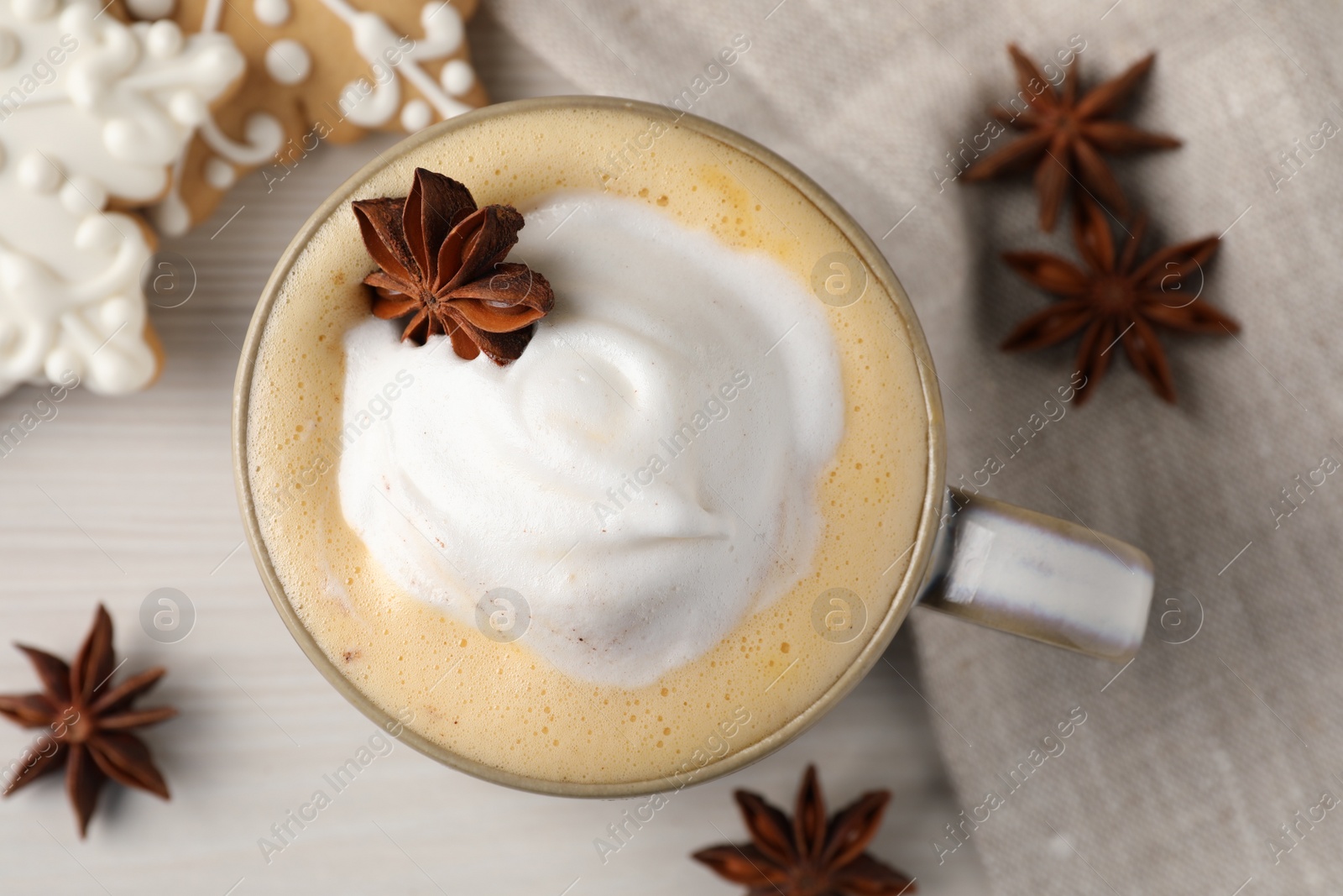 Photo of Cup of delicious eggnog with anise star on wooden table, flat lay