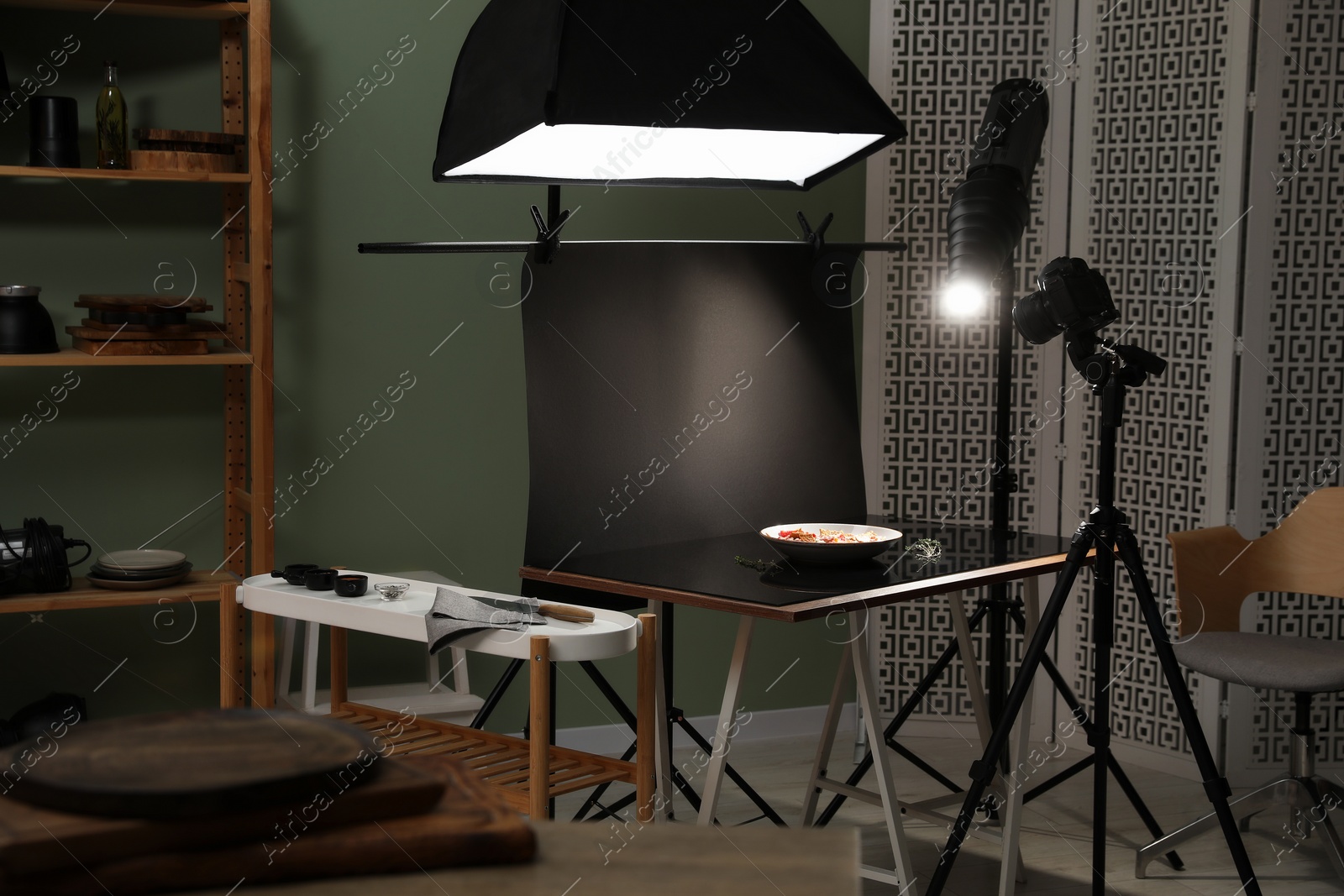 Photo of Professional equipment and salad with prosciutto on table in photo studio. Food photography