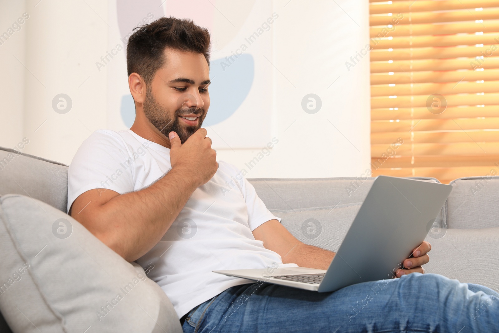 Photo of Man using laptop for online shopping at home