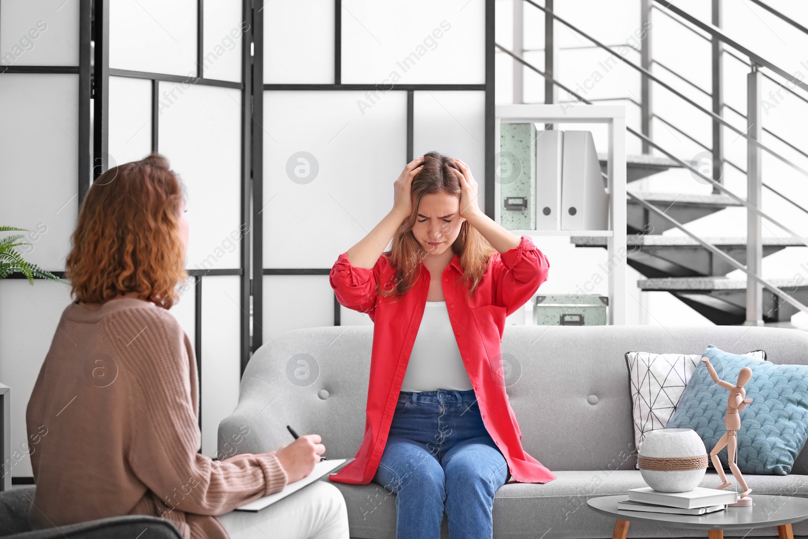 Photo of Child psychologist working with teenage girl in office