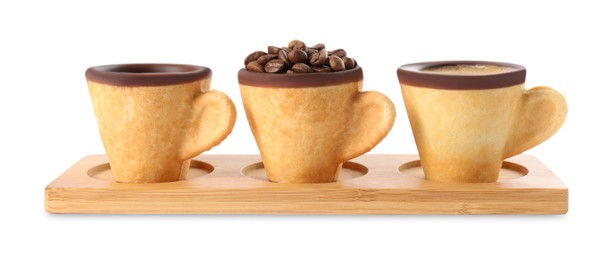 Photo of Edible biscuit cups with espresso, coffee beans and empty one on white background