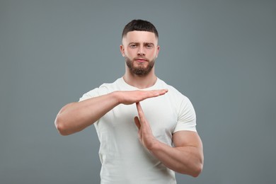 Photo of Man showing time out gesture on grey background
