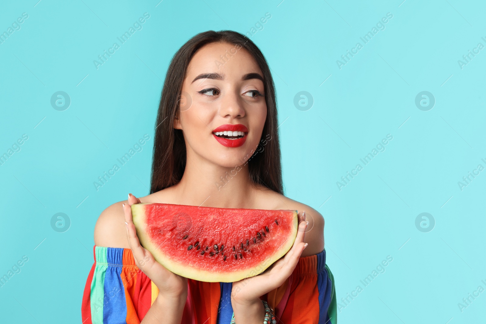 Photo of Beautiful young woman posing with watermelon on color background