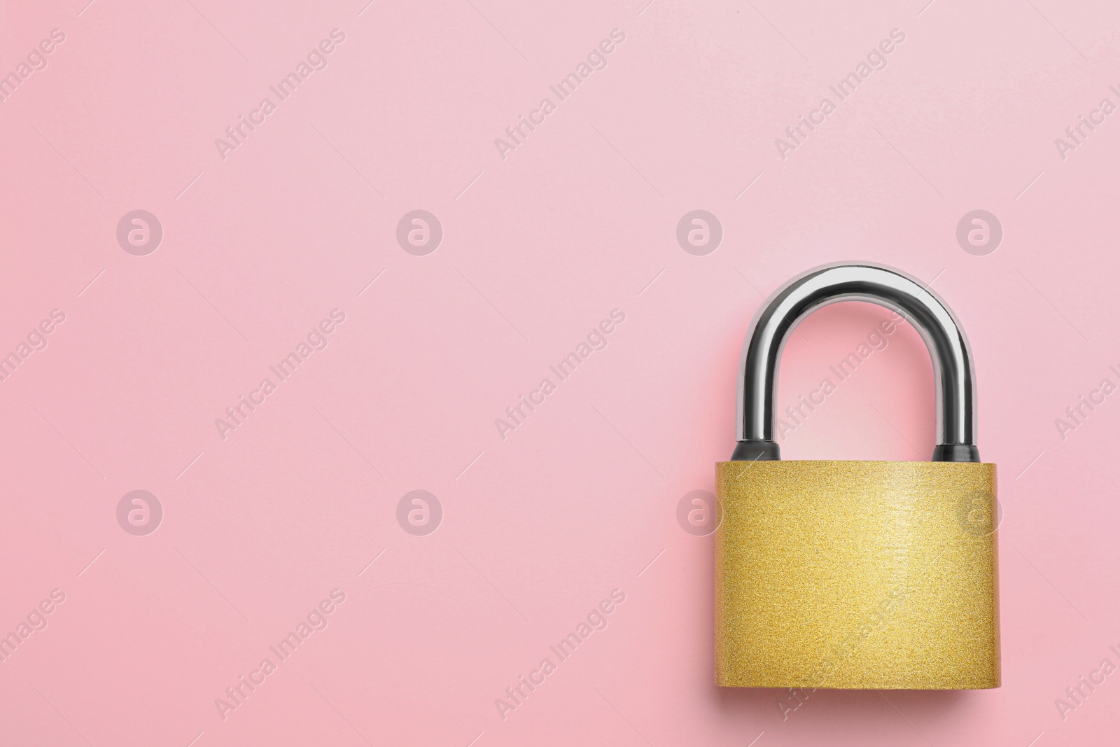 Photo of Modern padlock on pink background, top view. Space for text