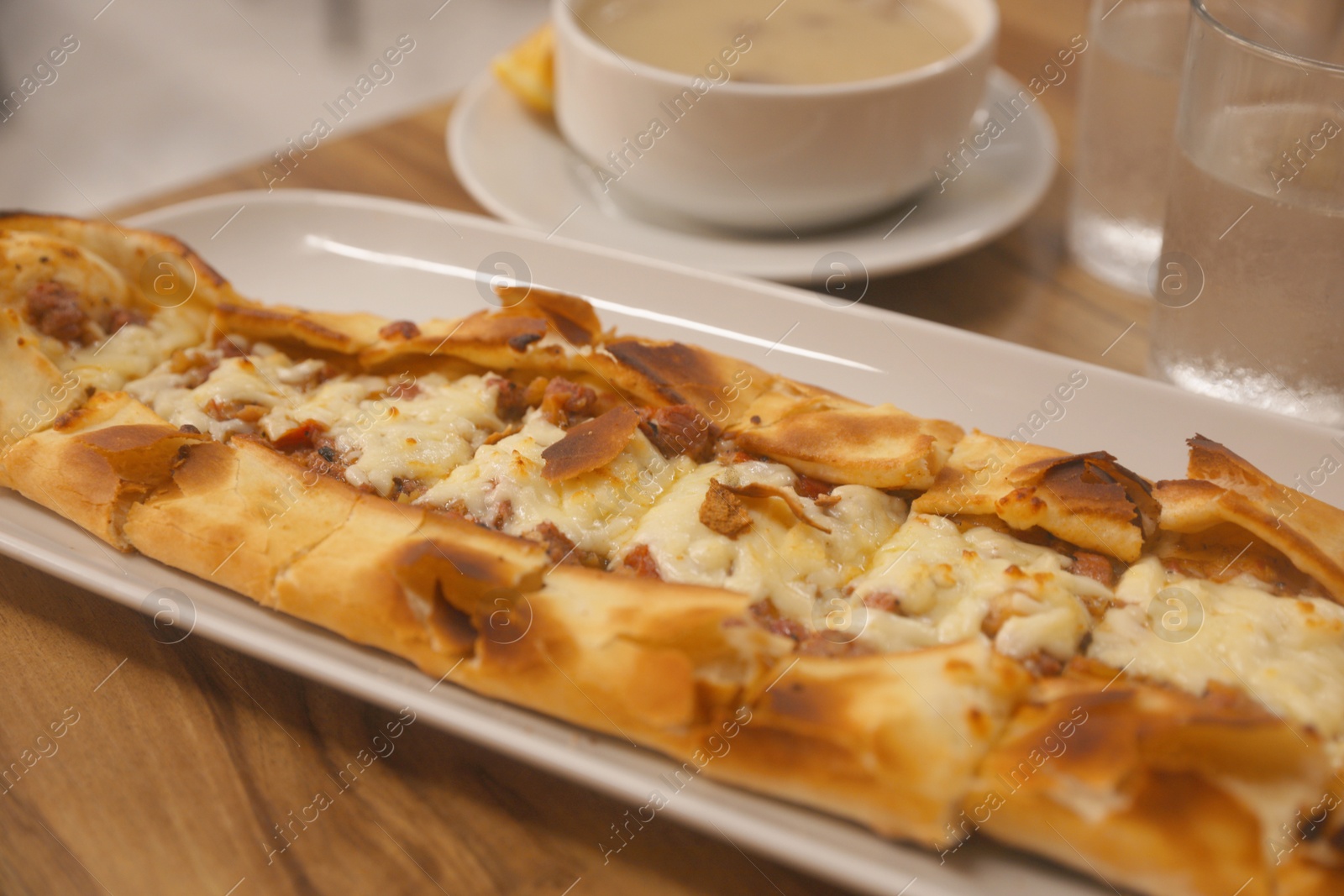 Photo of Delicious pide on wooden table, closeup. Traditional Turkish street food