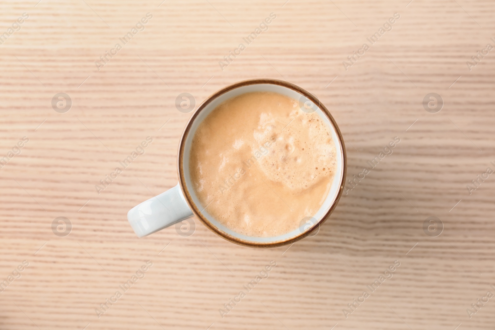 Photo of Cup of aromatic hot coffee on wooden background, top view