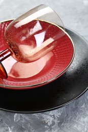 Photo of Clean plates, bowl and glass on gray table, closeup