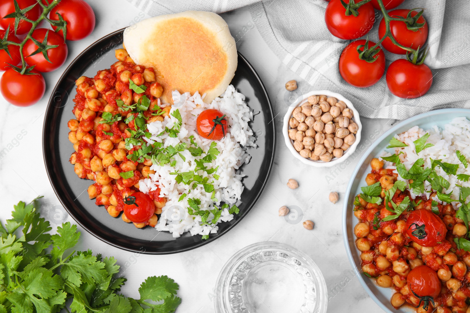 Photo of Delicious chickpea curry with rice served on white marble table, flat lay