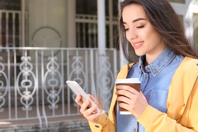 Photo of Young woman using phone outdoors on sunny day