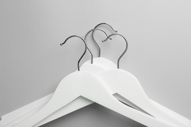 Photo of White hangers on light gray background, top view