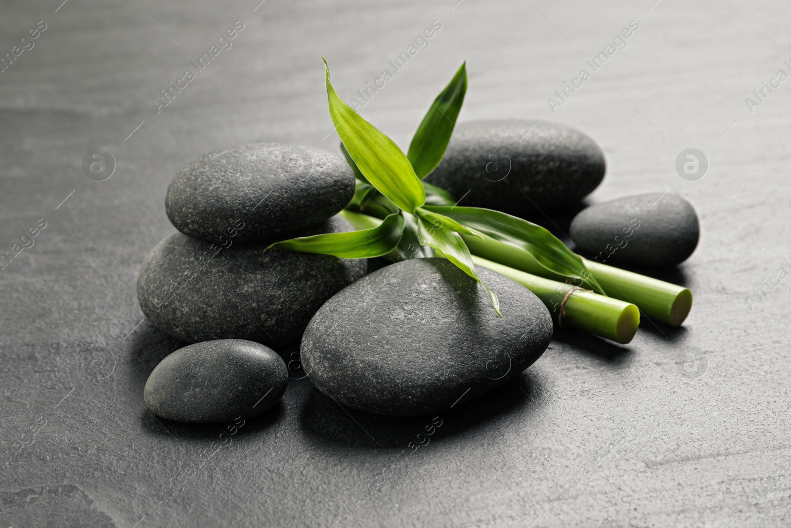 Photo of Spa stones and bamboo stems on grey table