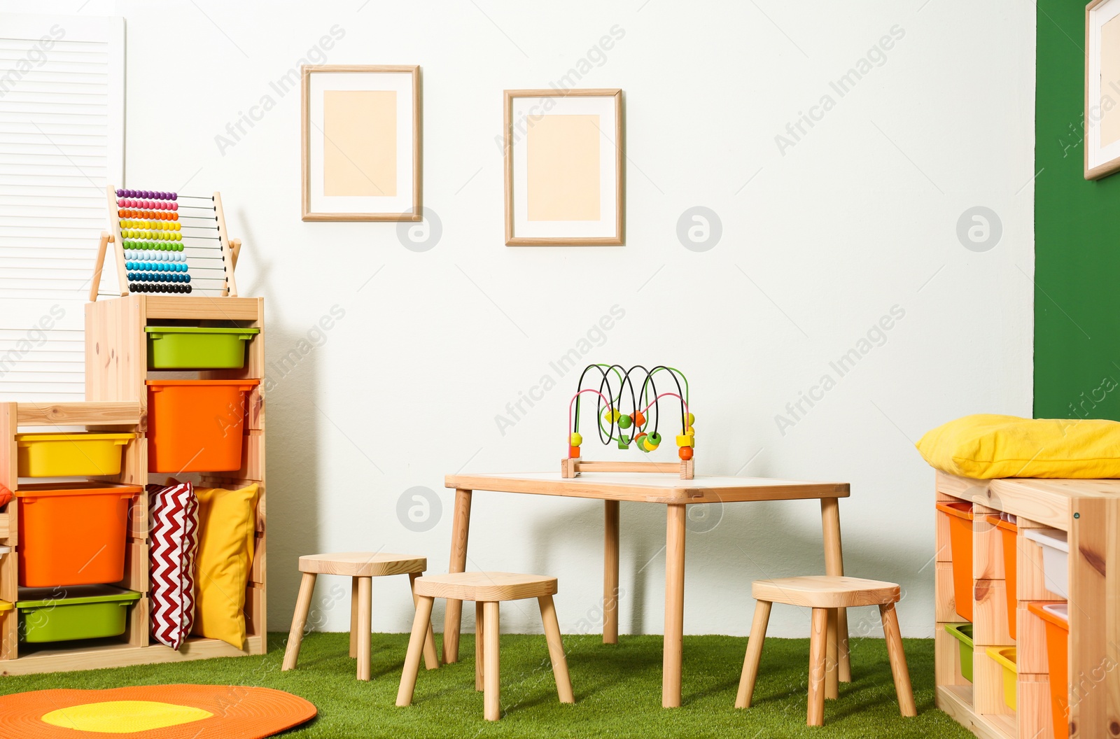 Photo of Stylish playroom interior with table and stools