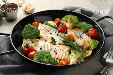 Photo of Tasty cod cooked with vegetables served on grey table