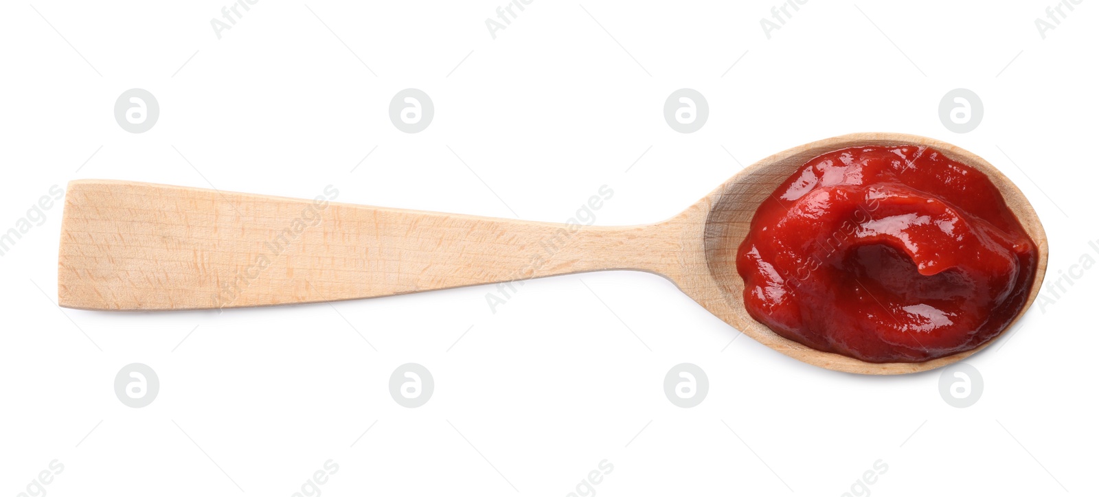 Photo of Tasty ketchup in wooden spoon isolated on white, top view