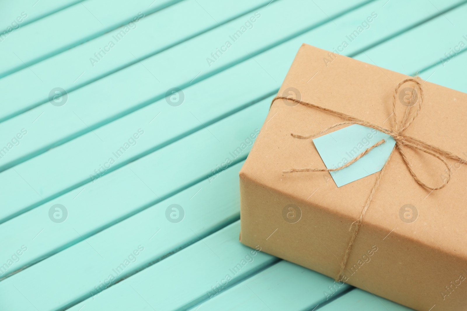 Photo of Parcel with tag on wooden background. Space for text