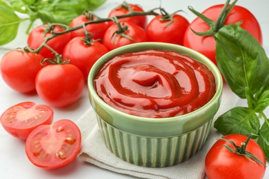 Photo of Bowl of tasty ketchup, tomatoes and basil on white table, closeup