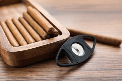 Cigars and guillotine cutter on wooden table