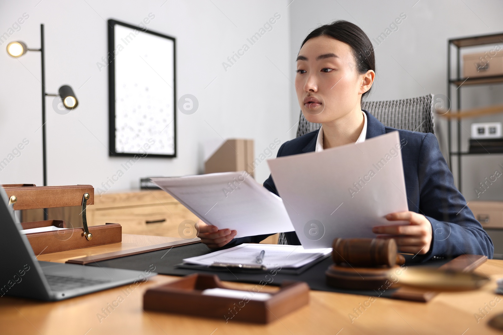 Photo of Notary reading documents at table in office