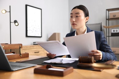 Photo of Notary reading documents at table in office