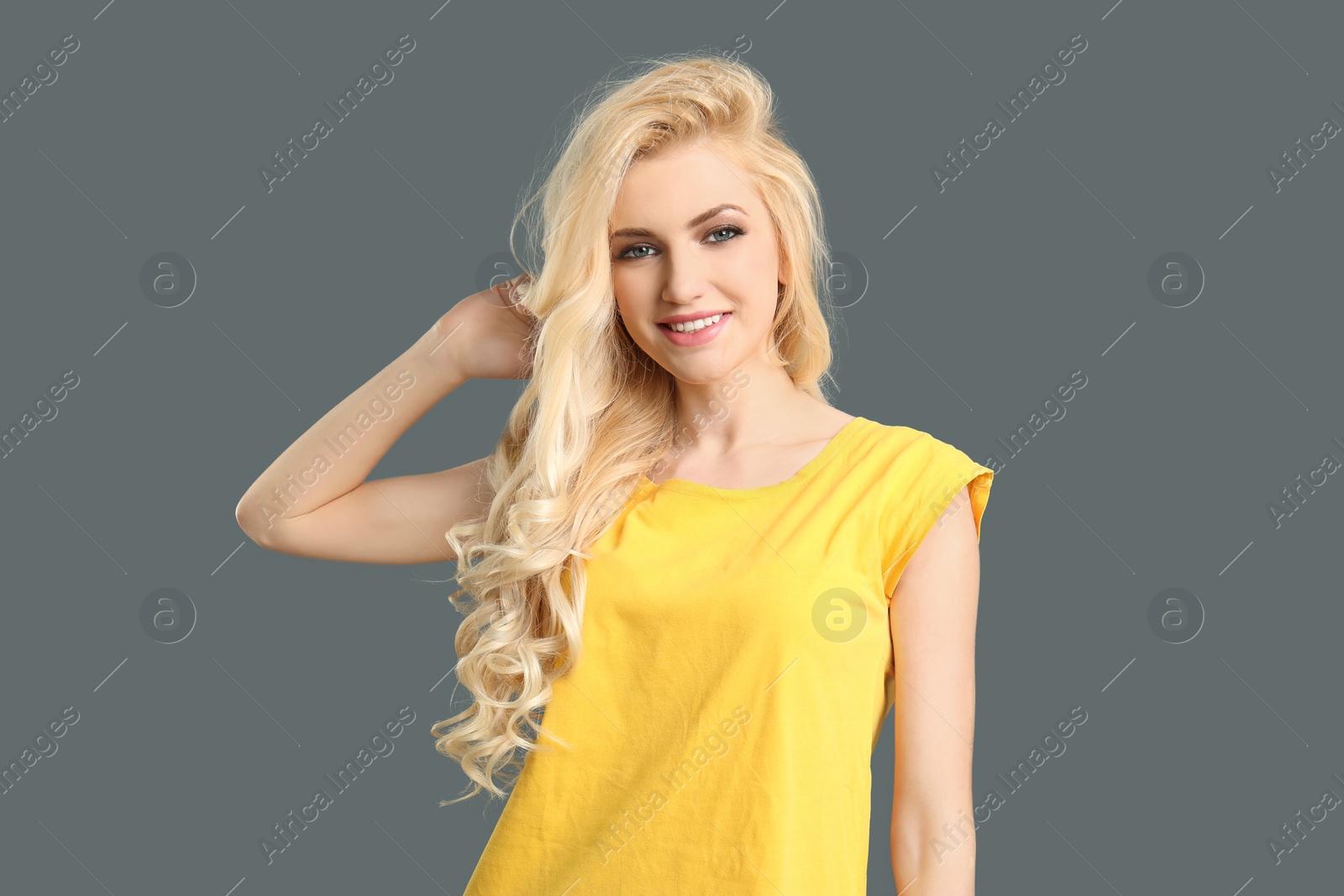 Photo of Portrait of young model with beautiful  hair on grey background