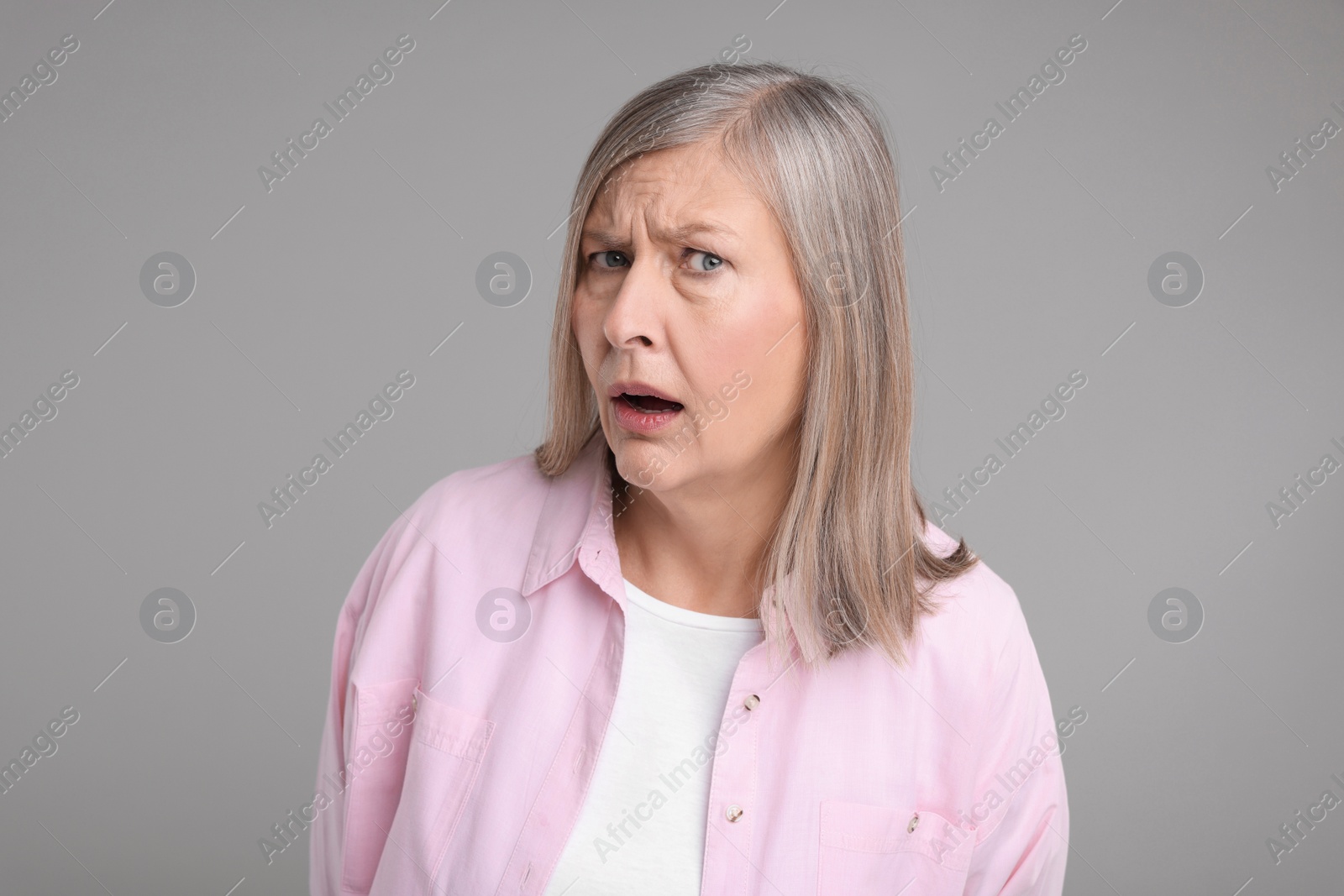 Photo of Portrait of surprised senior woman on grey background