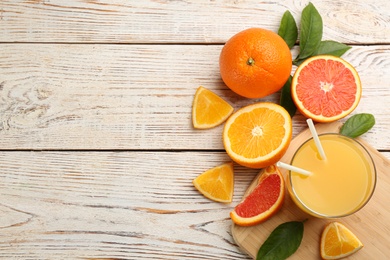 Photo of Delicious orange juice and fresh fruits on white wooden table, flat lay. Space for text