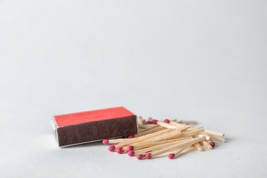 Cardboard box and matches on light background