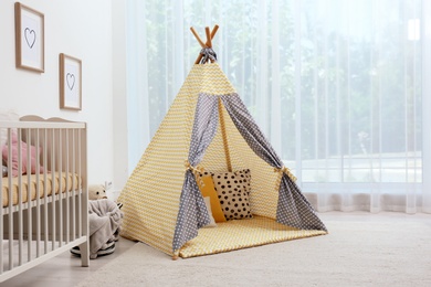 Photo of Cozy baby room interior with play tent and toys
