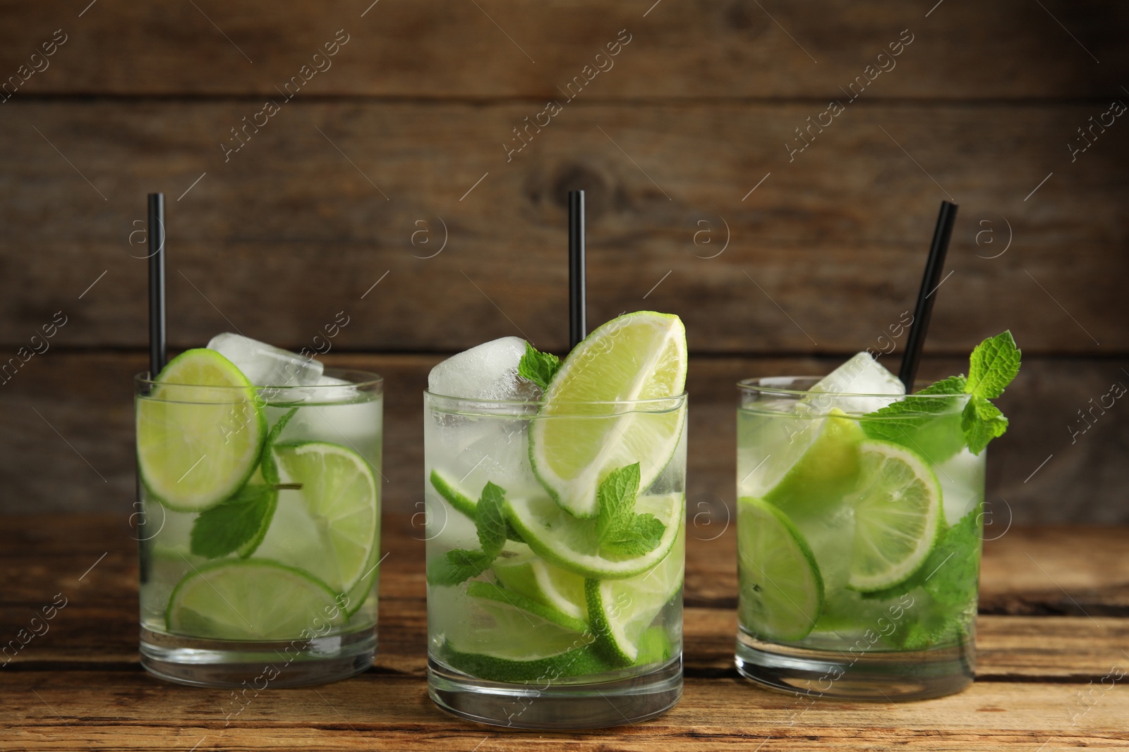 Photo of Delicious mojito and ingredients on wooden table