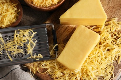 Photo of Grated, whole pieces of cheese and grater on table, top view