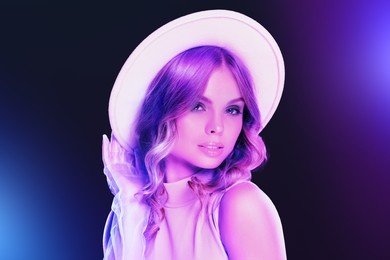 Image of Portrait of beautiful woman with hat in neon lights